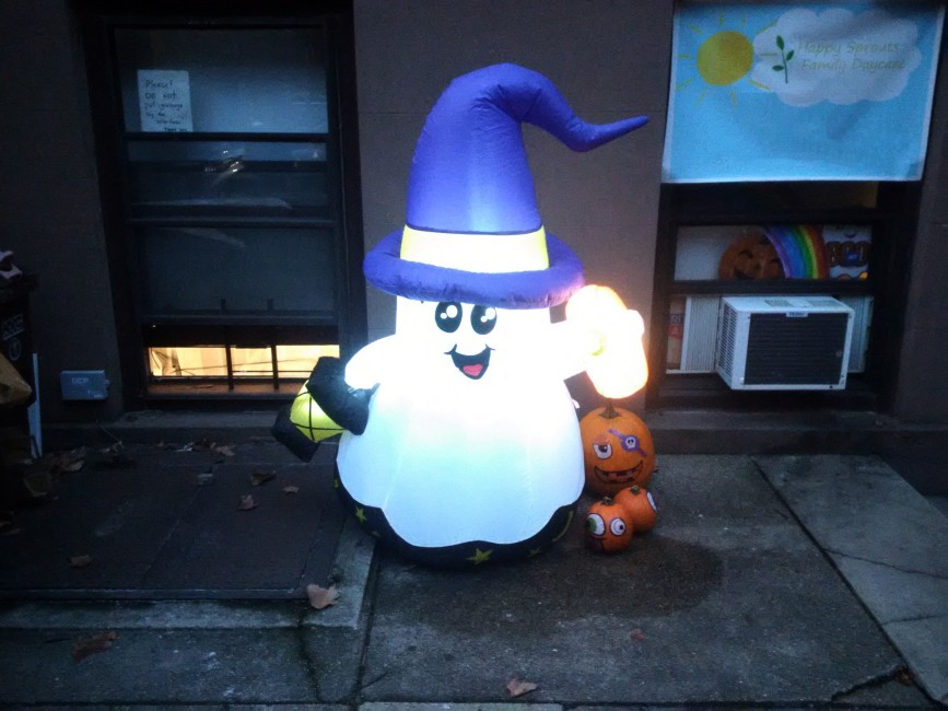 An inflatable Halloween ghost in front of a daycare that appears to be going on a trick-or-treating adventure.