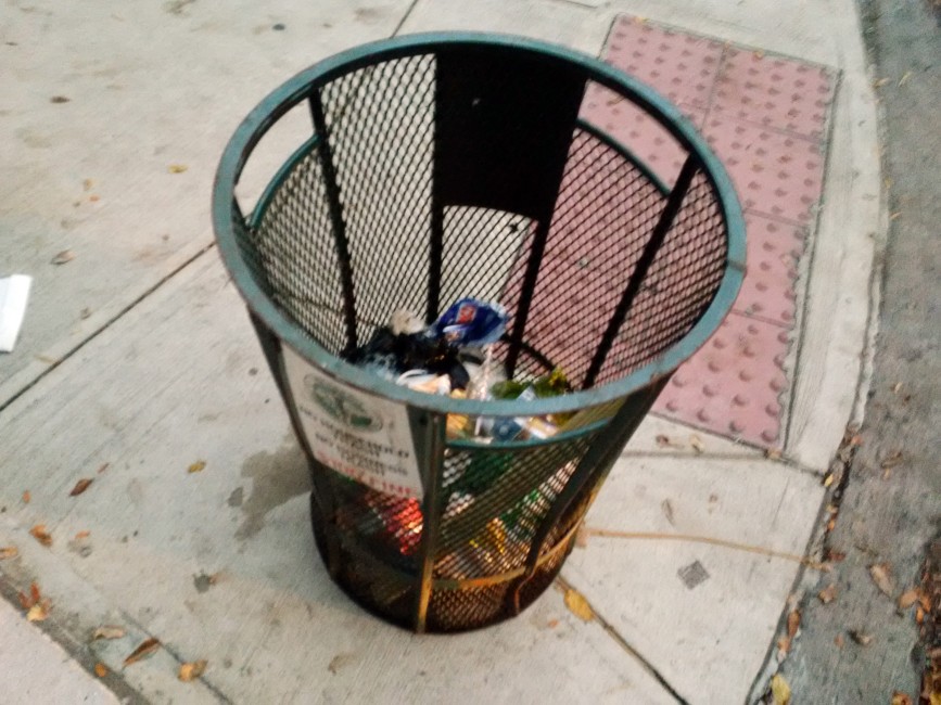 A standing trash can on a street corner in Gowanus.