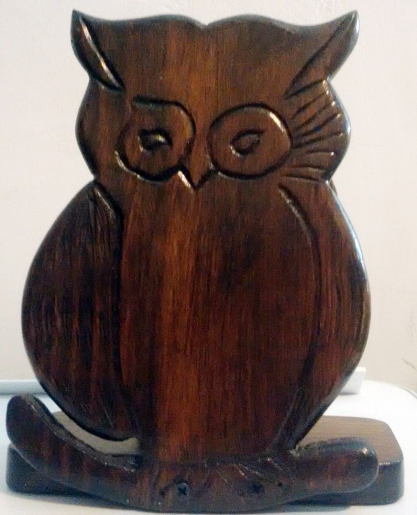 A peculiar homemade owl wooden carving, part of a stand for light stationary.