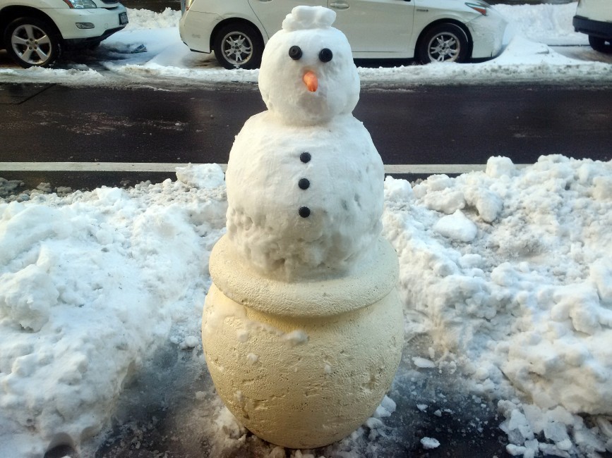 Snowman built on a planter in Brooklyn Heights after Winter Storm Gail.