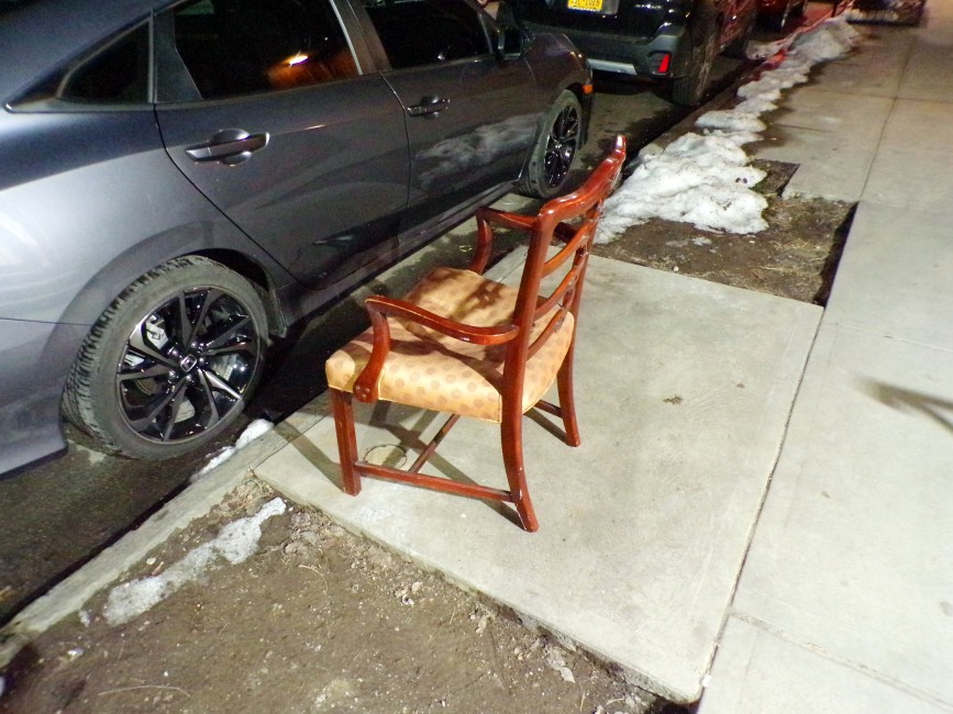 A discarded chair in fine condition sitting on Pacific Street in Brooklyn on a February evening.