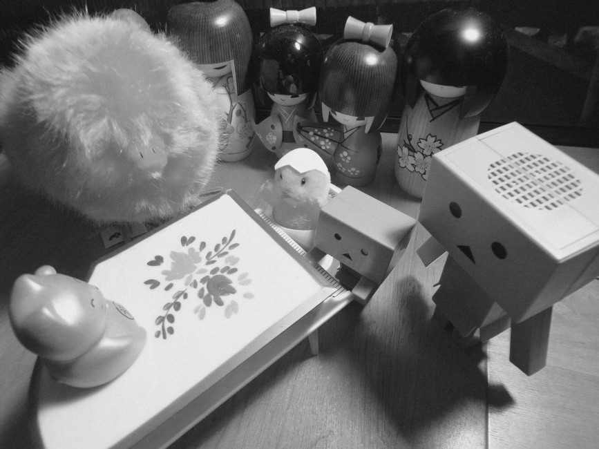 Hatchling and Danbo play the piano together in front of an audience of a chick, a larger Danbo, and four kokeshi dolls.