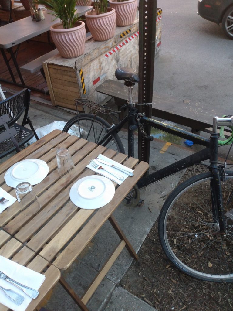 An outdoor dining set-up in Carroll Gardens, Brooklyn, with a bit of a standing water problem - photographed on May 18, 2021.