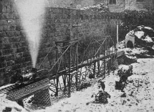 1895 photo of a model train crossing a model cantilever bridge.