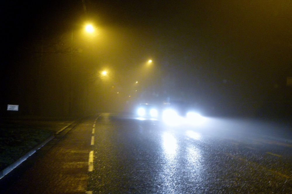 Cars with bright headlights on a rainy highway (Public Domain).