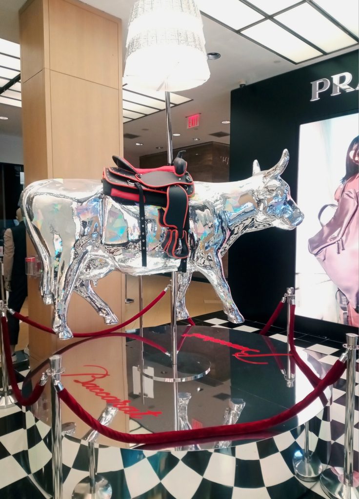 A picture of a silver cow statute sponsored by Baccarat for the 2021 NYC Cow Parade in Bloomingdale's on Lexington Avenue in Manhattan.
