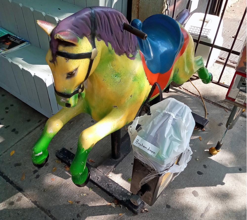 A broken down mutli-color kiddie horse seen outside a convenience store in Carroll Gardens, Brooklyn.