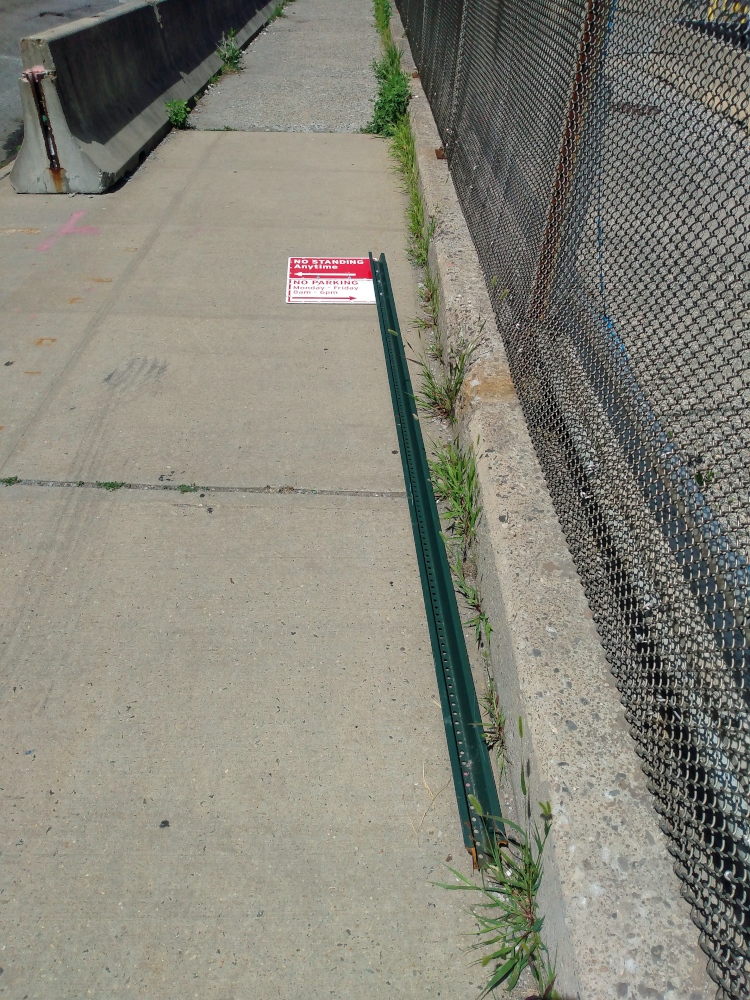 Photograph of a fallen "NO STANDING Anytime / NO PARKING" sign in Vinegar Hill, a small neighborhood in Brooklyn, New York City.