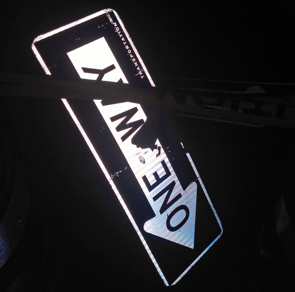 A downed one-way sign in Brooklyn Heights shines in the dark at night thanks to its high-visibility exterior.