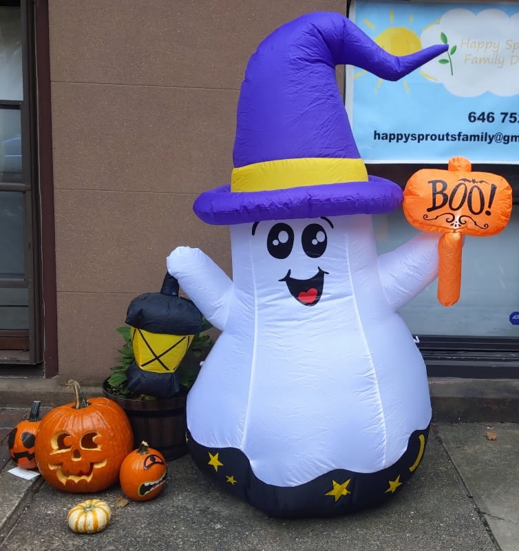 A happy inflatable ghost with a wizard's hat and a sign which says "BOO!" outside of a daycare in Cobble Hill, Brooklyn.