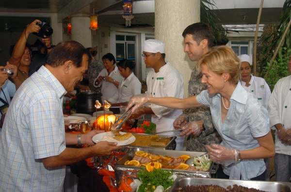 Then-U.S. Ambassador to the Philippines, Kristie A. Kenney, serves ham to the Mayor of Zamboanga City, Celso Lobreget, during the Thanksgiving Day dinner in 2007.  Credit:  U.S. Navy photo by Mass Communication Specialist 2nd class Shawn Gentile.