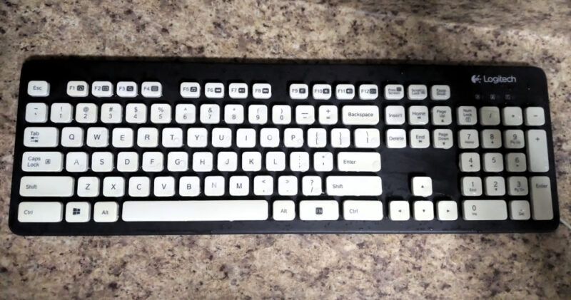 A wet Logitech Washable Wired K310 keyboard after having been washed and scrubbed in the sink.