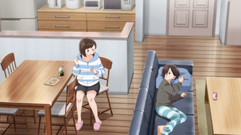 Kyoutarou is laying on a couch looking up at his sister Kana, who is sitting behind the couch on a chair at a table looking back at him. They are both in their pajamas.
