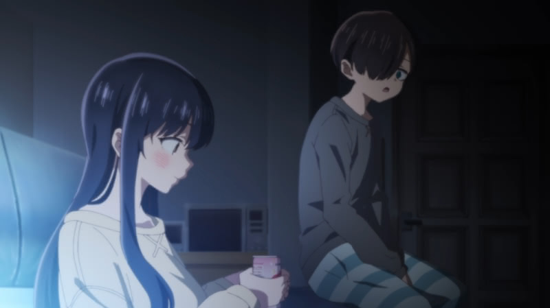 Kyoutarou saying something to Anna while she holds a drink at night in a living room.