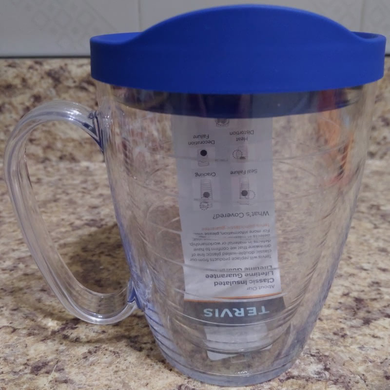 A 16 oz Tervis mug with handle and a blue lid. It still has the tag inside because it is fresh out of the box.