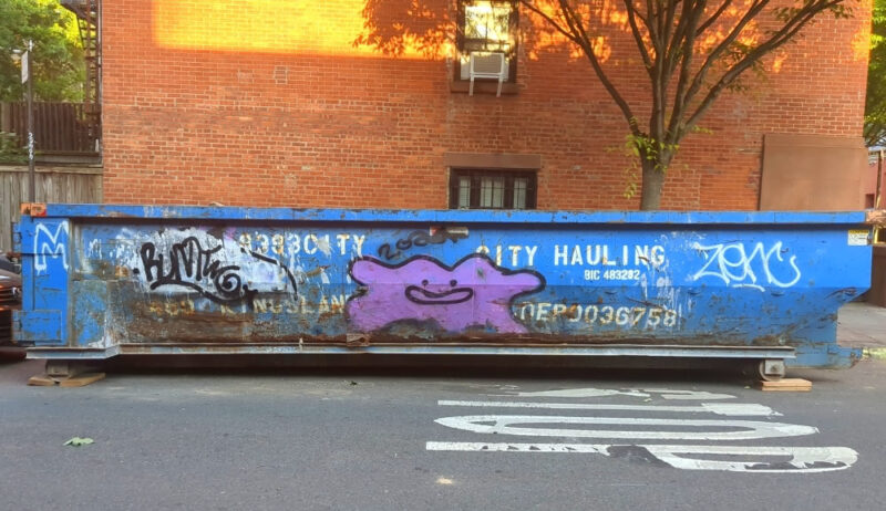 Photograph of a blue dumpster on Cheever Place in Brooklyn's Cobble Hill, just off Degraw Street. There is a Ditto from  Pokémon painted in the center of the dumpster.