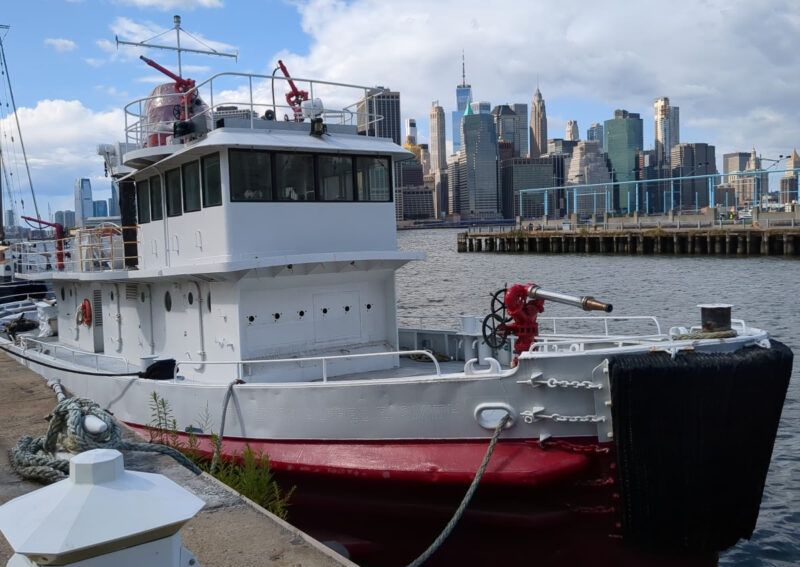 Old red and white boat docked off Pier Six in Brooklyn Bridge Park. You can see on the side of the boat the words Governor Alfred E. Smith, albeit they have been painted over.