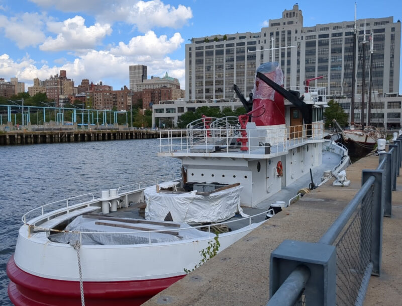 Photograph from the front of a red and  white boat named Governor Alfred E. Smith docked at Brooklyn Bridge Park.