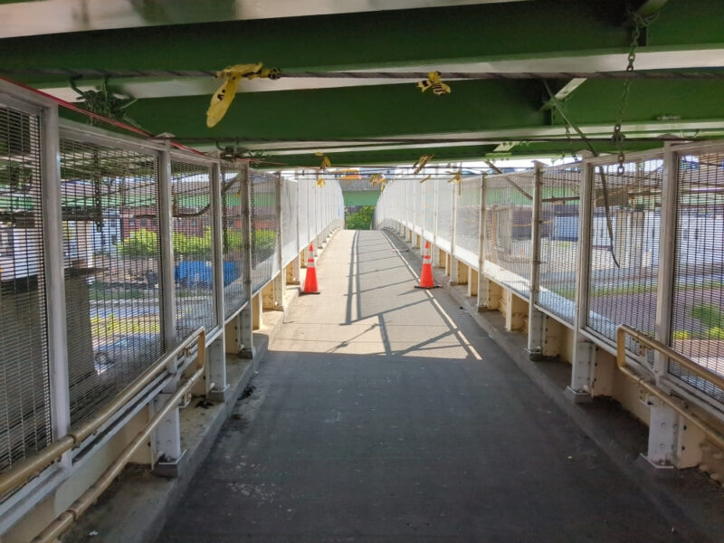 Hamilton Avenue Footbridge under overpass -- there are two orange traffic cones where the roof ends.