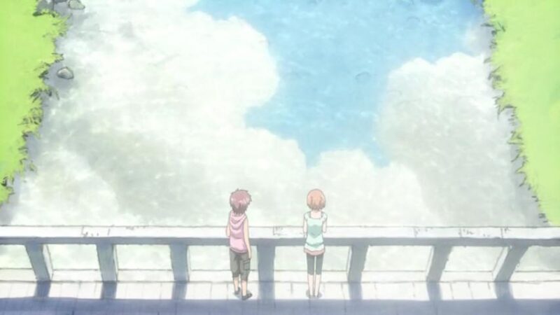 Tetsu and Karada stand on a bridge looking at the water, which has the blue sky and clouds reflected on its surface.