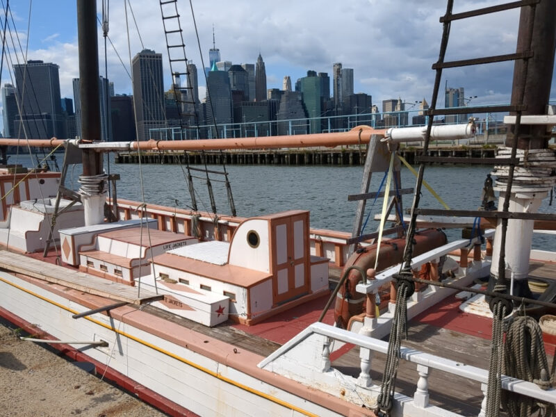 Mid-section of Victory Chimes schooner with the Manhattan skyline in the background.